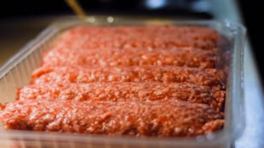 Pembe sosisli şeffaf bir kutu. Sosisler sıraya dizildi. Kaydırıcı atışı.