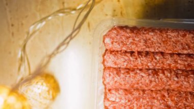 Pembe sosisli şeffaf bir kutu. Sosisler sıraya dizildi. Kaydırıcı atışı.