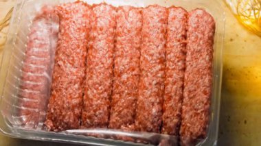 Pembe sosisli şeffaf bir kutu. Sosisler sıraya dizildi. Kaydırıcı atışı.