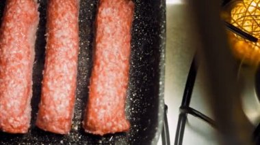 Pembe sosisler ızgara tavasında kızartılır. Sosisler sıraya dizildi. Sosisler buhar oldu. Kaydırıcı atışı.