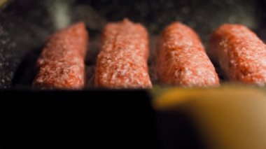 Pembe sosisler ızgara tavasında kızartılır. Sosisler sıraya dizildi. Sosisler buhar oldu. Kaydırıcı atışı.