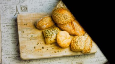 Ahşap masada farklı türde taze ekmek. Kahverengi arka planda münferit bir ekmek çeşidi. Kaydırıcı atışı.