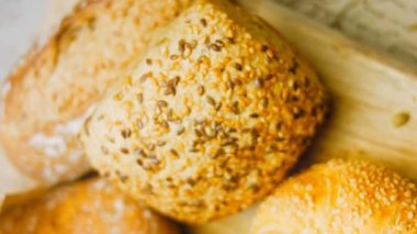 Ahşap masada farklı türde taze ekmek. Kahverengi arka planda münferit bir ekmek çeşidi. Kaydırıcı atışı.