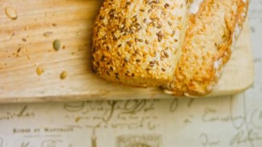 Ahşap masada farklı türde taze ekmek. Kahverengi arka planda münferit bir ekmek çeşidi. Kaydırıcı atışı.