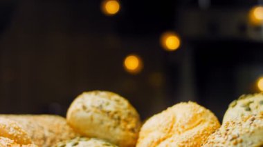 Ahşap masada farklı türde taze ekmek. Kahverengi arka planda münferit bir ekmek çeşidi. Kaydırıcı atışı.