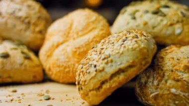 Ahşap masada farklı türde taze ekmek. Kahverengi arka planda münferit bir ekmek çeşidi. Kaydırıcı atışı.