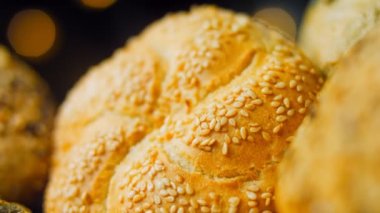 Ahşap masada farklı türde taze ekmek. Kahverengi arka planda münferit bir ekmek çeşidi. Kaydırıcı atışı.