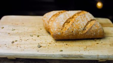 Çizgileri olan taze pişmiş kare ekmek. Gösteri için bir dilim ekmek kesilir. Arka planda romantik bir ortam var. Kaydırıcı atışı.