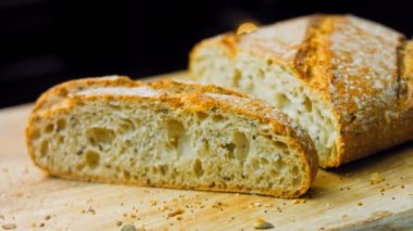 Çizgileri olan taze pişmiş kare ekmek. Gösteri için bir dilim ekmek kesilir. Arka planda romantik bir ortam var. Kaydırıcı atışı.