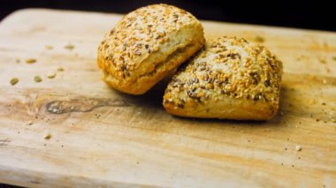 İki taze pişmiş kare ekmek ve tohum. Arka planda romantik bir ortam var. Makro ve sürgülü atış.