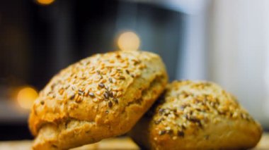 İki taze pişmiş kare ekmek ve tohum. Arka planda romantik bir ortam var. Makro ve sürgülü atış.