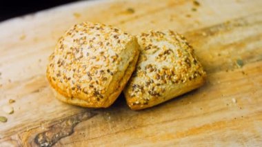 İki taze pişmiş kare ekmek ve tohum. Arka planda romantik bir ortam var. Makro ve sürgülü atış.