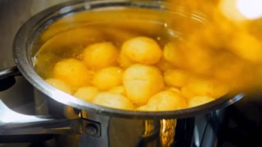 Yeni patatesleri metal bir kasede kaynatın. Kaydırıcı ve makro atış.