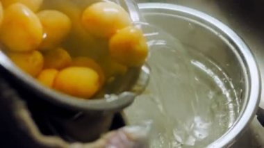 Aşçı taze haşlanmış patateslerin suyunu boşaltır. Kaydırıcı ve makro atış.