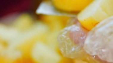 Şef taze haşlanmış patatesleri profesyonel bir bıçakla keser. Kaydırıcı ve makro atış.