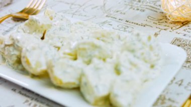 Mastard, mayonez, kırmızı soğan ve dereotlu patates salatası. Tarifi videoda göster.