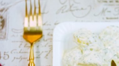 Mastard, mayonez, kırmızı soğan ve dereotlu patates salatası. Tarifi videoda göster.