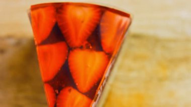 Çilek ve jöleli bir dilim pasta. Makro ve kaydırma atışı. Arka planda bir retro atmosfer var..