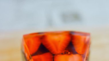 Çilek ve jöleli bir dilim pasta. Makro ve kaydırma atışı. Arka planda bir retro atmosfer var..