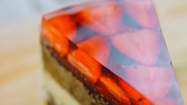 Çilek ve jöleli bir dilim pasta. Makro ve kaydırma atışı. Arka planda bir retro atmosfer var..