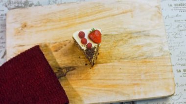 Bir dilim çilekli ve ahududulu kek ve çikolatalı dilimler. Makro ve kaydırma atışı. Arka planda bir retro atmosfer var..