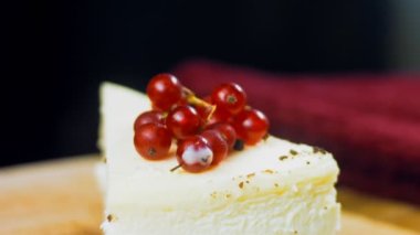 Frenk üzümlü bir dilim peynirli kek. Makro ve kaydırma atışı. Arka planda bir retro atmosfer var..