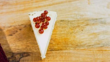 Frenk üzümlü bir dilim peynirli kek. Makro ve kaydırma atışı. Arka planda bir retro atmosfer var..