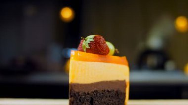 Turuncu şeftali ve çilek reçelli bir dilim pasta. Makro ve kaydırma atışı. Arka planda bir retro atmosfer var..