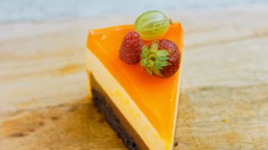 Turuncu şeftali ve çilek reçelli bir dilim pasta. Makro ve kaydırma atışı. Arka planda bir retro atmosfer var..