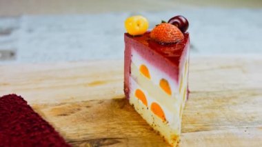 Çilekli, beyaz ve kırmızı kirazlı bir dilim pasta. Pastanın özel bir kubbesi var. Makro ve kaydırma atışı. Arka planda bir retro atmosfer var..