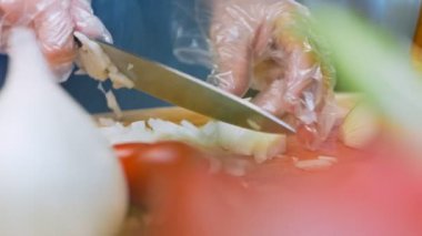 Aşçı soğanın nasıl küp kesileceğini gösteriyor..