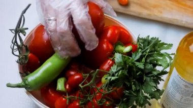Front view of the young chef cut thin slices of a piece of red pepper with a knife on the cutting board. Front view of a young chef cutting thin slices of a piece of red pepper. Vegetables up close.