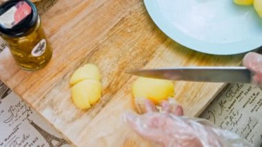 Kadın şefin elleri kızartma ya da güveç için patates dilimleri kesiyor. Ev yapımı tarifte pişirme sürecinin bir parçası.