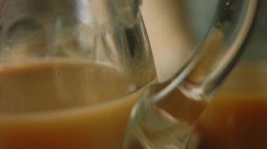 Annesi yemek hazırlarken küçük kız bir bardak meyve suyu içiyor..