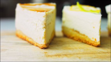 Arka arkaya dizilmiş dört çeşit cheesecake. Kaypak ve makro atış. Bir retro stil pişirme tahtası kullanılır.