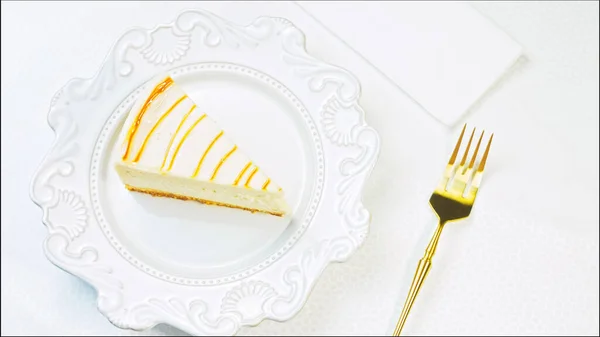 The cook puts the fork on the table. Caramel cheesecake on a retro plate. Use a gold fork and knife.