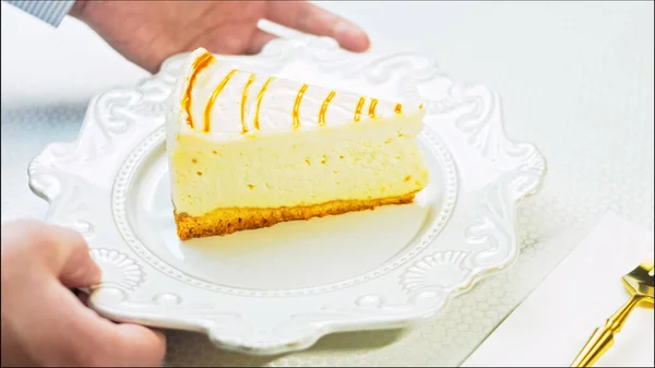 The cook puts the fork on the table. Caramel cheesecake on a retro plate. Use a gold fork and knife.