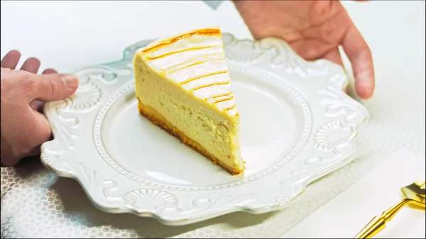The cook puts the fork on the table. Caramel cheesecake on a retro plate. Use a gold fork and knife.