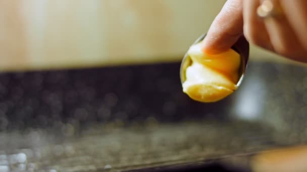 Ajouter une cuillerée de beurre. Gros plan suivi de l'oignon rouge haché et de l'ail frit dans du beurre pétillant dans une casserole.