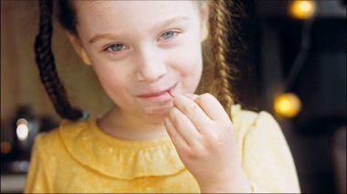 Retro kek tepsisinde vişneli ve çikolatalı pasta. Pasta zarif boncuklarla süslenmiş. Şef altın çatalda bir parça kek saklıyor. Küçük kız pastayı tadıyor ve çok tatlı.