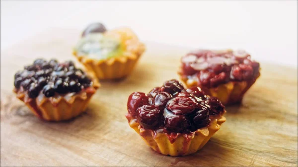 A variety of cake baskets with berries. The cakes are beautifully decorated on a retro-style cooking tray.