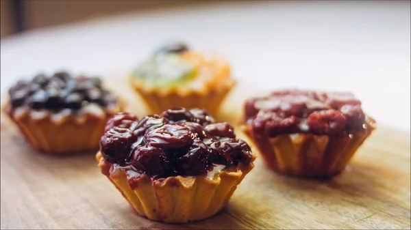 A variety of cake baskets with berries. The cakes are beautifully decorated on a retro-style cooking tray.