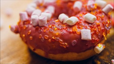 Marshmello ile süslenmiş pembe çörekler. Makro ve kaydırma atışı. Fırın ve yemek konsepti. Çeşitli renkli çörekler..