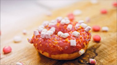 Marshmello ile süslenmiş pembe çörekler. Makro ve kaydırma atışı. Fırın ve yemek konsepti. Çeşitli renkli çörekler..