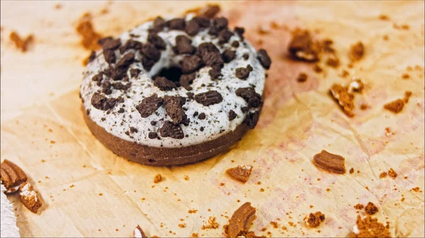 巧克力甜甜圈 上面装饰着一些意大利饼干 甜甜圈在用天然巧克力装饰的纸上 宏观和滑翔机射击 面包店和食品概念 各种彩色甜甜圈 巧克力味的 — 图库照片