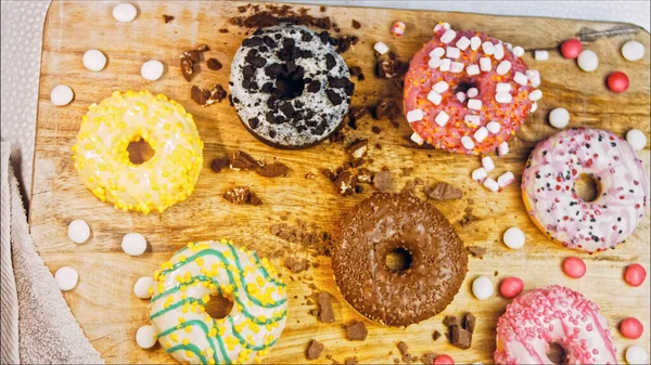 Chocolate, marshmello and candy donuts on a retro baking tray. Donuts are on a paper decorated with natural chocolate. Macro and slider shooting. Various colorful donuts. Chocolate, pink, blue donuts.