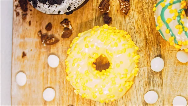 Chocolate, marshmello and candy donuts on a retro baking tray. Donuts are on a paper decorated with natural chocolate. Macro and slider shooting. Various colorful donuts. Chocolate, pink, blue donuts.