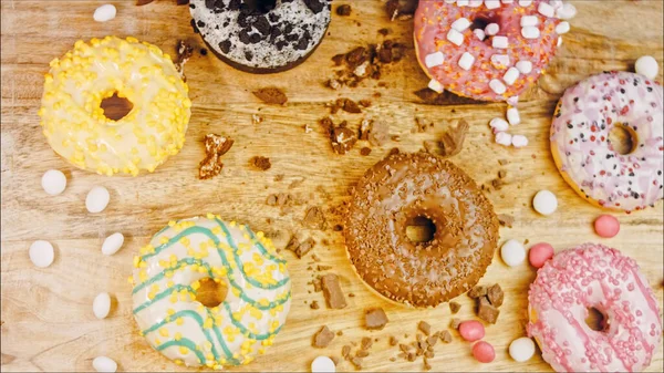 Chocolate, marshmello and candy donuts on a retro baking tray. Donuts are on a paper decorated with natural chocolate. Macro and slider shooting. Various colorful donuts. Chocolate, pink, blue donuts.