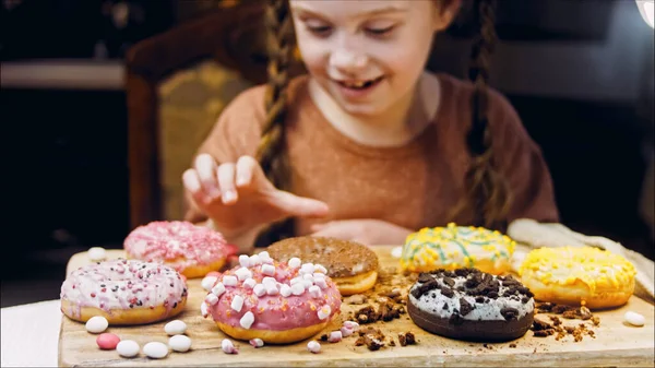 Menina Escolhe Entre Vários Presentes Ela Aponta Dedo Donuts Chocolate Fotos De Bancos De Imagens