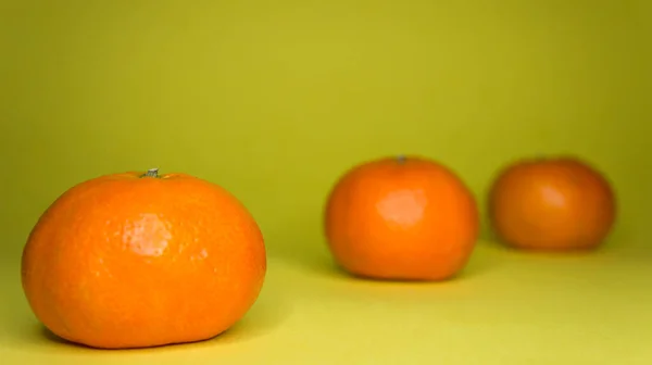 Sarı arka planda mandalinalar, narenciye fotoğrafçılığı.